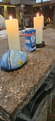 Auf dem Altar steht zwischen den Kerzen ein Päckchen Salz, daneben ein bemalter Stein