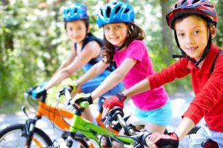Drei Kinder auf dem Fahrrad mit Helmen