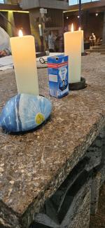 Auf dem Altar steht zwischen den Kerzen ein Päckchen Salz, daneben ein bemalter Stein